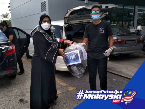 Sukarelawan UTHM menyerahkan bungkusan 'boot cover' kepada wakil Task Force C-19 Johor untuk proses mendapat kelulusan sebelum diserahkan kepada pihak hospital.