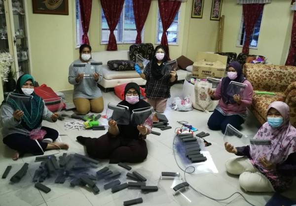 Zarina (depan, tengah) dan ahli PERKEP IPD Hulu Terengganu bersama pelindung muka yang dihasilkan.