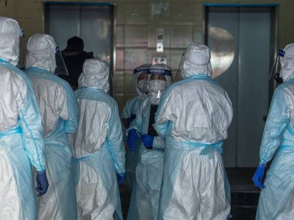 Para petugas Kementerian Kesihatan melakukan pemeriksaan serta ujian saringan COVID-19 setiap penghuni Flat Selangor Mansion hari ini. - Foto Bernama