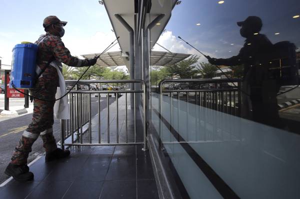 Anggota Unit Khas Bahan Kimia Berbahaya (HAZMAT) Jabatan Bomba dan Penyelamat Negeri Sembilan mempergiatkan semburan sanitasi di persekitaran sebuah pasar. -Foto Bernama