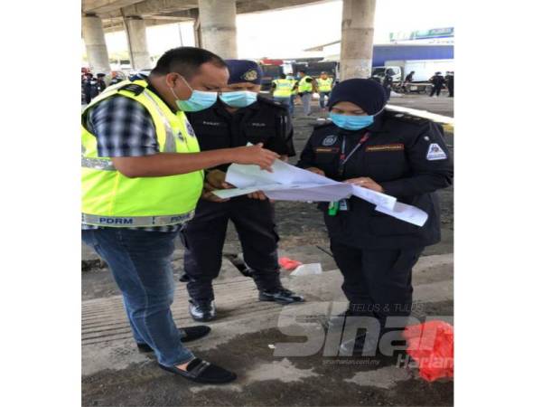 Norhayati (kanan) berbincang dengan pegawai polis tentang lokasi yang perlu diberi perhatian untuk tindakan penguatkuasaan.