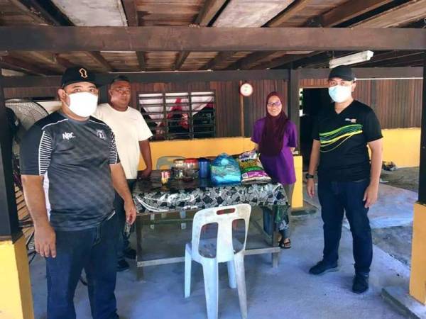 Mohd Imran (kanan) menyampaikan sumbangan kepada salah seorang penerima di DUN Sungai Panjang di sini.