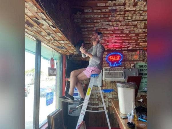 Sukarelawan mengutip semula wang ditampal pada dinding. - Foto Jennifer Knox