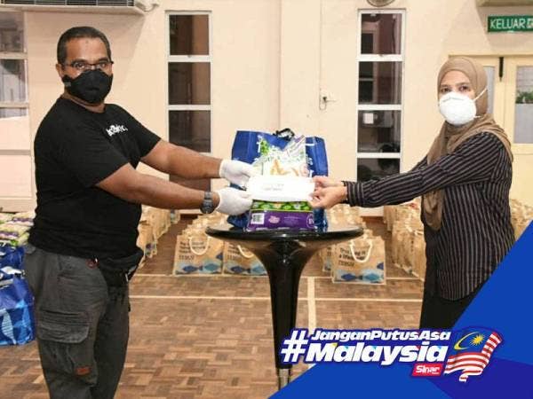 Rahilah menyampaikan sumbangan kepada salah seorang penerima bantuan MDKS hari ini.