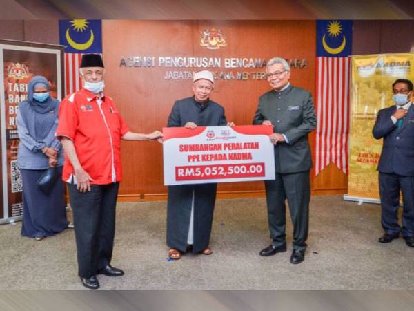 Zulkifli (dua dari kiri) menyerahkan sumbangan itu kepada Redzuan untuk kegunaan patugas barisan hadapan.