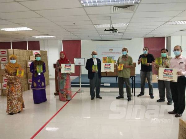 Hashim menyerahkan sumbangan Program Wakaf Quran kepada Dr Sha'ari di JKN Selangor di sini hari ini. -FOTO: ASRIL ASWANDI SHUKOR