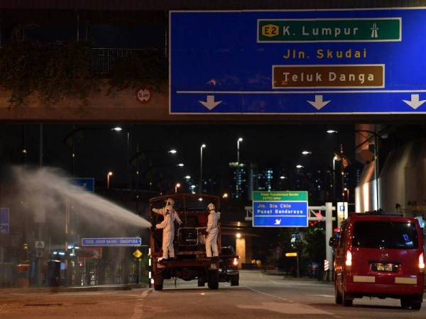 Anggota Bomba dan Penyelamat menjalankan kerja-kerja penyahkuman atau disinfeksi di sekitar pusat bandaraya Johor sebagai langkah mencegah penularan koronavirus (Covid-19) malam tadi. - Foto Bernama
