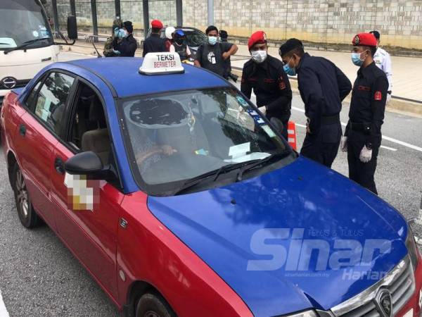 Nik Ezanee memeriksa pengguna jalan raya yang melalui sekatan jalan raya di Jalan PJU 7/1 Mutiara Damansara, Petaling Jaya, Selangor, hari ini.