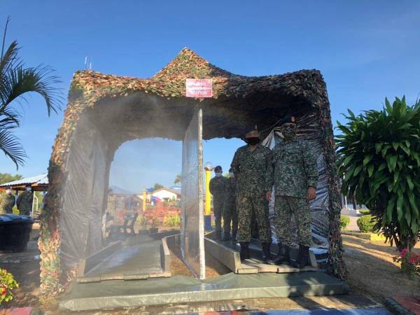 Zamsari (kanan) yang melawat 'Rapid Decon Stesen' yang dikhaskan kepada anggota dalaman yang masuk ke Kem Desa Pahlawan Kok Lanas.