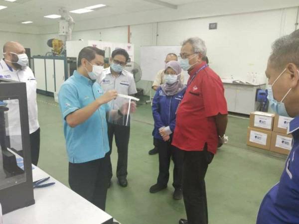 Mohd Redzuan (tengah) diberi taklimat mengenai pembuatan UTeM Shield.