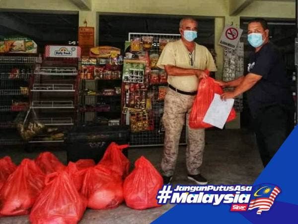 Nazri (kiri) menyampaikan sumbangan kepada penduduk terlibat di beberapa buah kampung di Ulu Tembeling.

