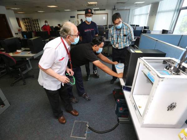 Naib Canselor UNITEN, Profesor Datuk Ir Dr Kamal Nasharuddin Mustapha (kiri) melihat proses pembuatan pelindung muka dengan menggunakan pencetak 3D di UNITEN baru-baru ini.