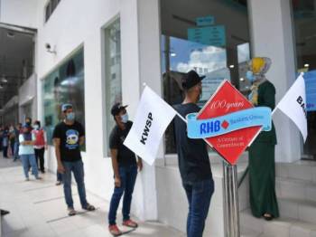 Orang ramai mematuhi jarak sosial 1 meter ketika beratur bagi urusan permohonan Skim Pengeluaran Wang Akaun 2 i-Lestari, Kumpulan Wang Simpanan Pekerja (KWSP) di RHB Bank ketika tinjauan Perintah Kawalan Pergerakan (PKP) yang masuk hari ke-26 hari ini. - Foto Bernama