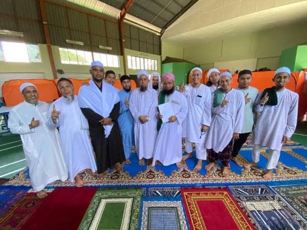 Mohd Abdul Salam (tengah) bersama 13 jemaah tabligh Kuantan tiba dari Miri, Sarawak hari ini. 