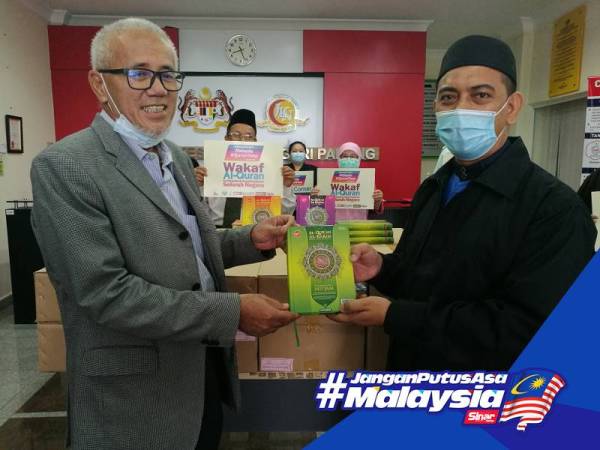 Md Abdu (kanan) menyerahkan sumbangan Projek Wakaf Al-Quran kepada Dr Bahari di Pejabat JKN Pahang semalam. 