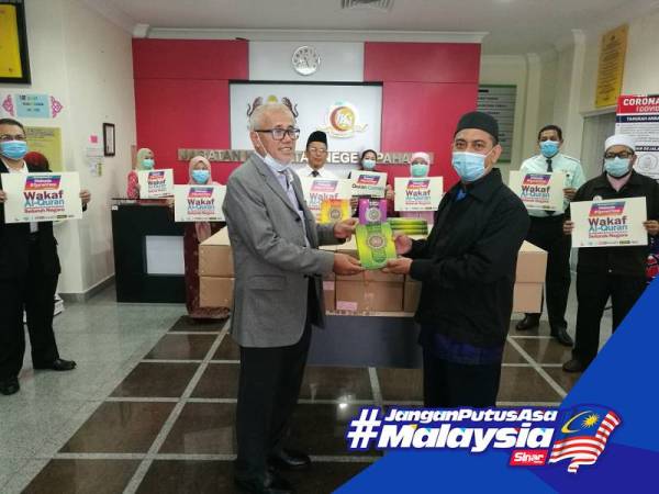 Md Abdu (kanan) menyerahkan sumbangan Projek Wakaf Al-Quran kepada Dr Bahari di Pejabat JKN Pahang semalam. 