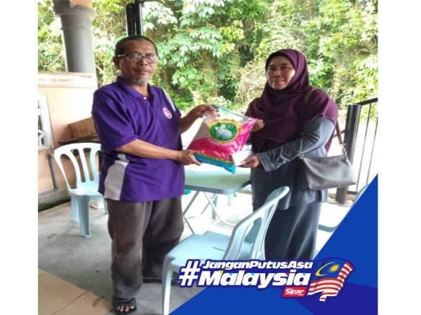 Tuan Mohd Noor menyerahkan beras kepada Mariam bagi meringankan beban ibu tunggal tersebut.