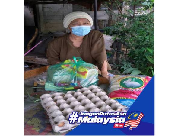 Penduduk menerima barangan dapur hasil sumbangan Pertubuhan Kebajikan Penduduk Mukim Parit Pasir Tumboh.