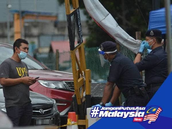 Anggota PDRM sedang mengawal dan memantau pergerakan keluar masuk di Pangsapuri PKNS Kampong Bharu hari ini. Foto: SHARIFUDIN ABDUL RAHIM