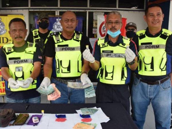 Hanyan (dua, kiri) bersama pegawainya menunjukkan barangan rampasan.