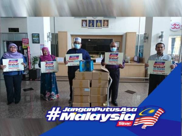 Ismail (dua dari kanan) ketika menerima sebahagian daripada 1,500 naskhah al-Quran di Wisma Persekutuan di Ayer Keroh di sini hari ini.