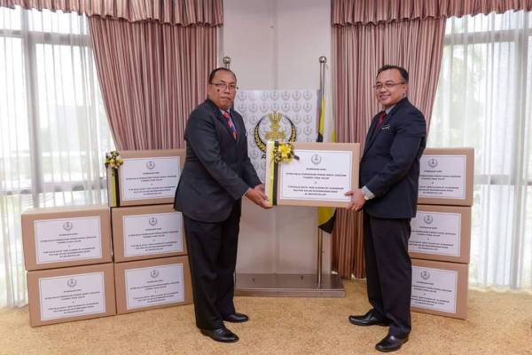 Ahmad Suaidi (kanan) mewakili kerajaan negeri menyerahkan sumbangan pelindung muka kurniaan Tuanku Zara dan Raja Eleena kepada Mohamad Ghopran. -Foto: SUK Perak