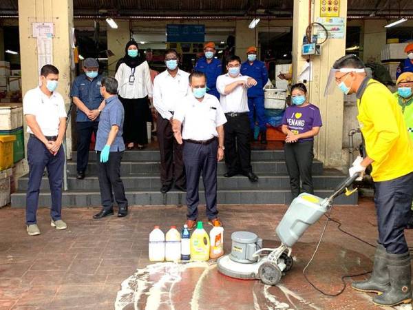Jagdeep (tengah) sedang melihat kakitangan MBPP yang melakukan kerja pembersihan pada lantai Pasar Awam Jelutong di sini hari ini.