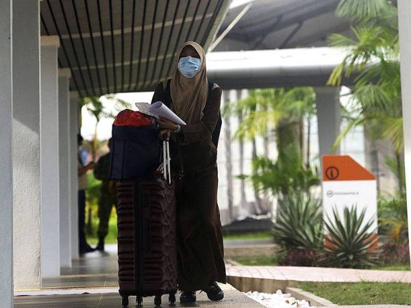 Seorang individu yang di bawah pengawasan menunggu ahli keluarga selepas dibenarkan pulang setelah tamat proses kuarantin ketika tinjauan di Pusat Pemantauan Akademi Kepimpinan Pendidikan Tinggi (AKEPT), hari ini. - Foto Bernama