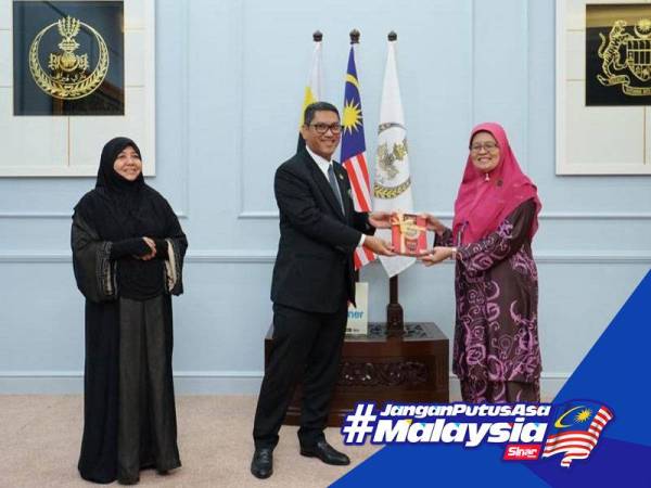 Ahmad Faizal menyampaikan sumbangan al-Quran kepada Norisah (kanan) pada majlis Penyerahan Sumbangan Wakaf al-Quran.