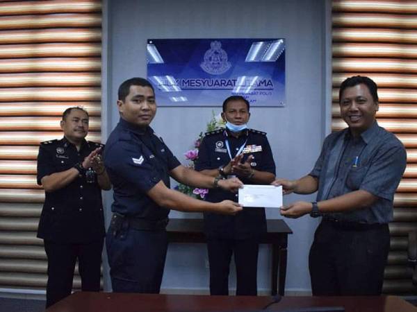 Mohd Azad (kiri) menerima surat penghargaan daripada Tengku Permaisuri Selangor, Tengku Permaisuri Norashikin yang disampaikan oleh Pembantu Setiausaha Sulit kepada Sultan Selangor, Muhammad Syahir Hasan (kanan). -Foto: Ihsan FB Polis IPD Shah Alam