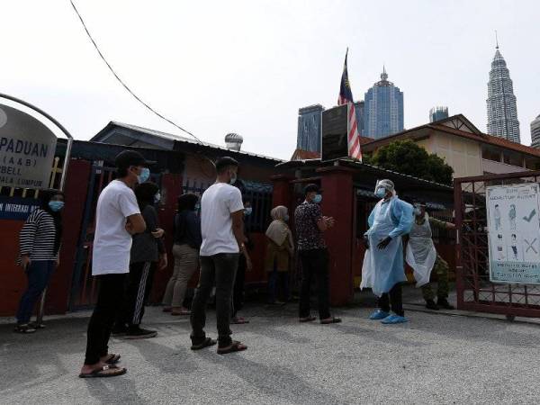 Sebahagian penduduk di Kampong Bharu beratur menunggu giliran untuk melakukan pemeriksaan saringan Covid-19 di Sekolah Rendah Agama Jalan Raja Muda Musa hari ini.