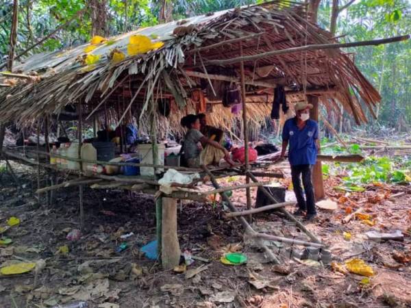 Cikgu Mie agih bantuan kepada Orang Asli walau terpaksa redah hutan.