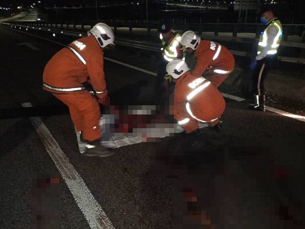 Anggota bomba membantu mengalihkan mayat mangsa.