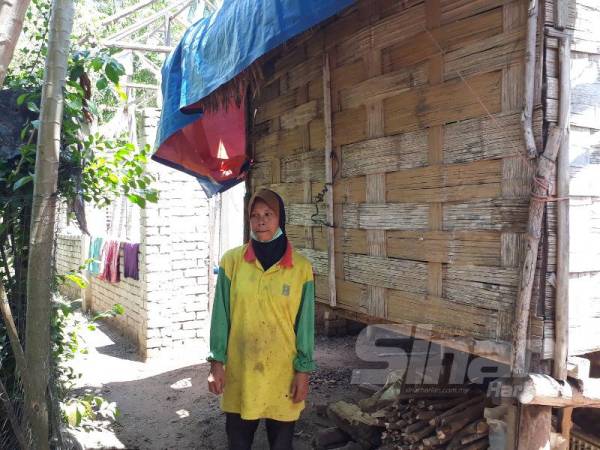 Rumah baru (kiri) yang dibina Syarifah sejak 2018 masih belum siap berikutan dihimpit masalah kemiskinan. 