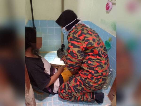 Anggota bomba berusaha mengeluarkan kaki mangsa.