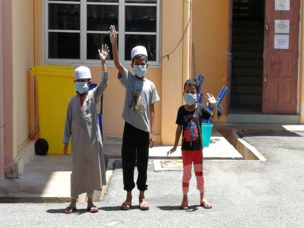 Hussain dan adik-adiknya melambai tangan kegembiraan selepas disahkan negatif Covid-19 dan dibenarkan pulang. 