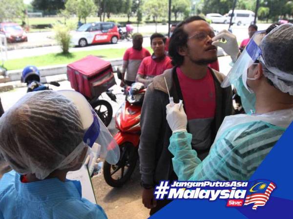 Penghantar makanan membuat saringan Covid-19 dikendalikan petugas kesihatan Selcare secara pandu lalu dan percuma di Dewan Raja Muda Musa Seksyen 7 Shah Alam, semalam. - FOTOASRIL ASWANDI ABDUL SHUKOR