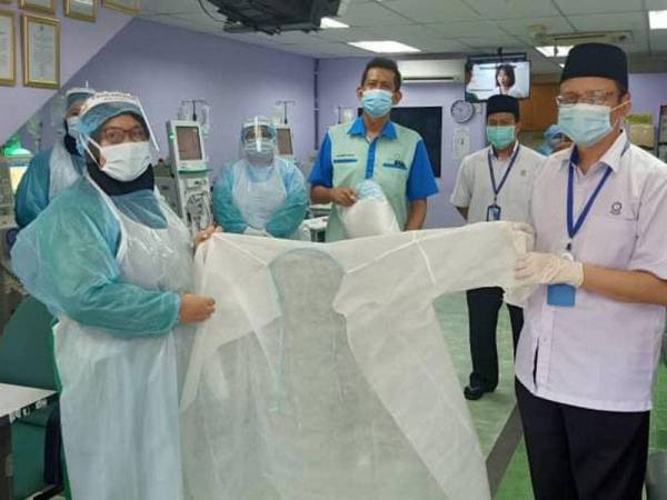 Ahmad Shahir (kanan) menyampaikan PPE kepada salah sebuah pusat dialisis di bawah seliaan YIDE.