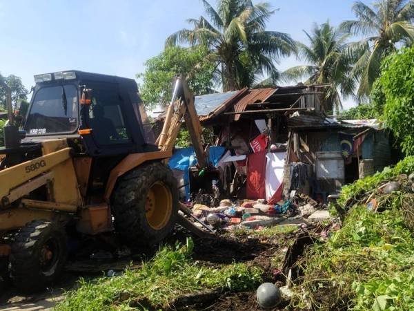 Kerja merobohkan rumah lama Pak Ishak menggunakan jentolak di Lorong Gedebang, di sini hari ini.