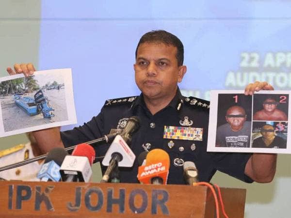 Ayob Khan menunjukkan foto bot pancung, tekong dan dua pembantunya yang ditahan pada sidang akhbar di IPK Johor hari ini.