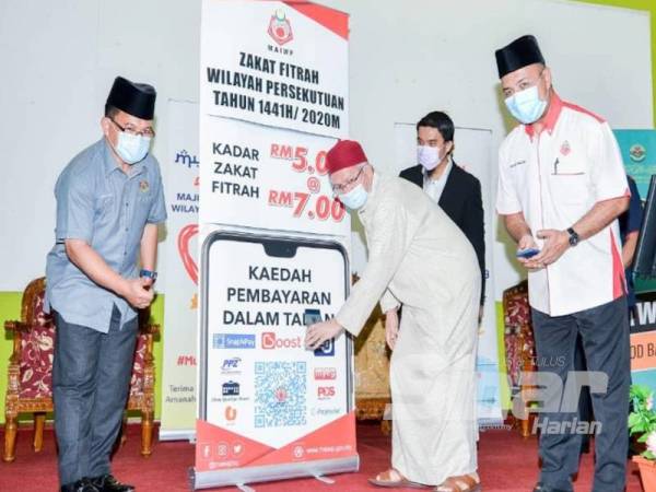 Zulkifli (dua dari kiri) membuat gimik pelancaran bayaran zakat fitrah secara dalam talian dalam majlis berlangsung di Majid Salahuddin Al-Ayubi di sini hari ini.