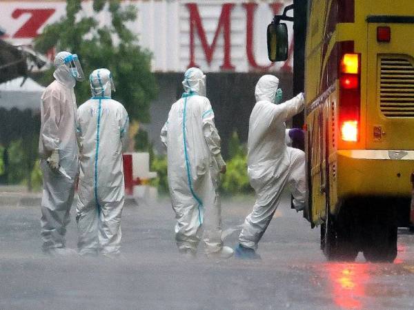 Petugas Kementerian Kesihatan Malaysia (KKM) dilihat kekal bertugas meskipun dalam keadaan hujan lebat di kawasan Perintah Kawalan Pergerakan Diperketatkan (PKPD) berhampiran Menara City One hari ini. Foto: Bernama