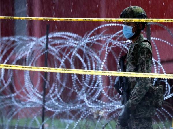 Anggota Angkatan Tentera Malaysia (ATM) tetap berkawal meskipun dalam keadaan hujan lebat di kawasan Perintah Kawalan Pergerakan Diperketakan (PKPD) berhampiran Menara City One hari ini. Foto: Bernama