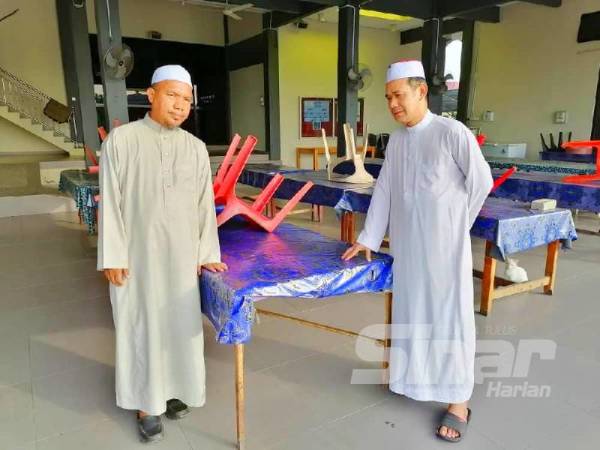 Ismail (kiri) dan Ab Razak hanya mampu melihat kerusi meja dikemas kerana tiada majlis berbuka puasa akan diadakan pada Ramadan kali ini.