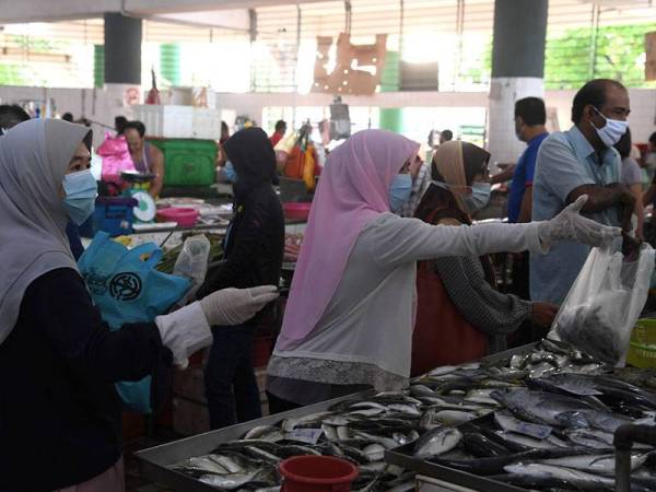Umat Islam membeli barang keperluan sebagai persiapan menyambut Ramadan esok, dengan mengamalkan penjarakan sosial dan memakai penutup hidung dan mulut di Kompleks Pasar dan Balai Rakyat Bayan Baru hari ini. - Foto Bernama