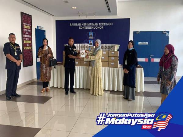 Roziah menyerahkan 500 naskhah al-Quran kepada Ayob Khan di IPK Johor, Johor Bahru