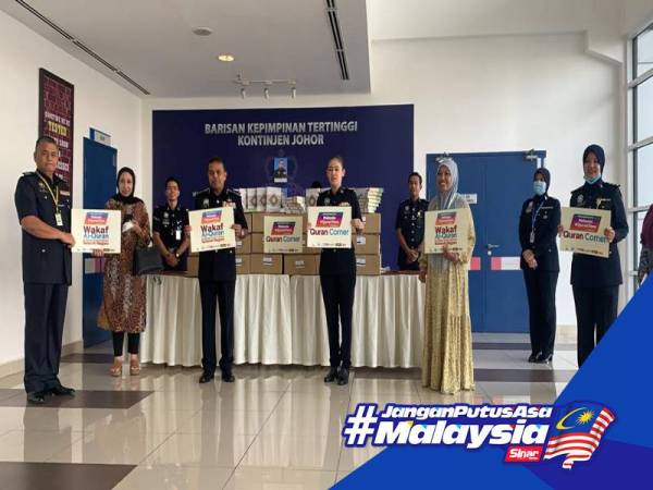 Roziah menyerahkan 500 naskhah al-Quran kepada Ayob Khan di IPK Johor, Johor Bahru hari ini.