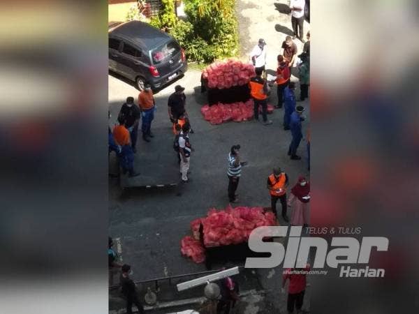 Petugas sedang menguruskan agihan bantuan makanan kepada penduduk.