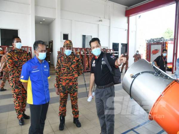 Dr Shahriman (kanan) memberi penerangan kepada anggota bomba tentang SP-C19 TMMD. 