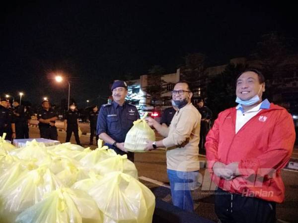 Razarudin menerima bungkusan makanan bersahur daripada Zainol Fadzi dan Yahanis. 